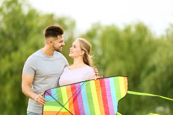 Happy young couple with kite outdoors — Stock Photo, Image