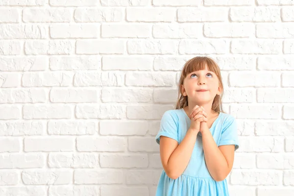 Μικρό κορίτσι προσεύχεται σε άσπρο φόντο — Φωτογραφία Αρχείου