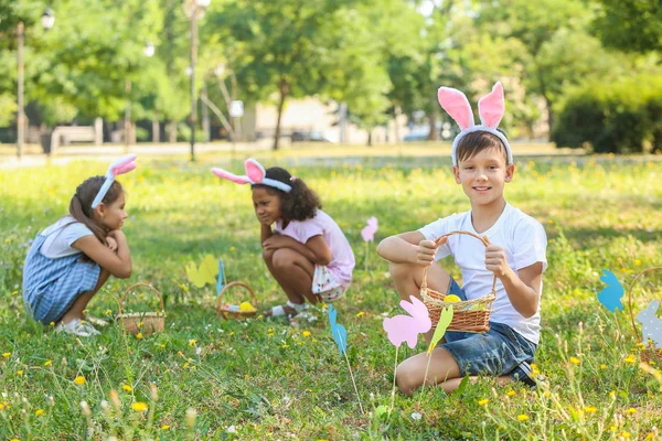 Crianças pequenas que recolhem ovos de Páscoa no parque — Fotografia de Stock