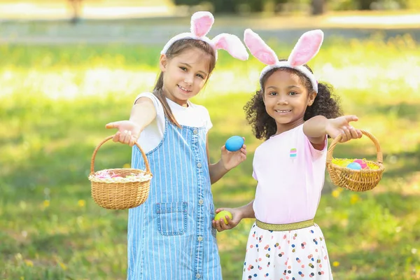 Kleine meisjes verzamelen paaseieren in Park — Stockfoto