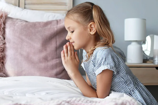 Söt liten flicka som ber i sovrummet — Stockfoto
