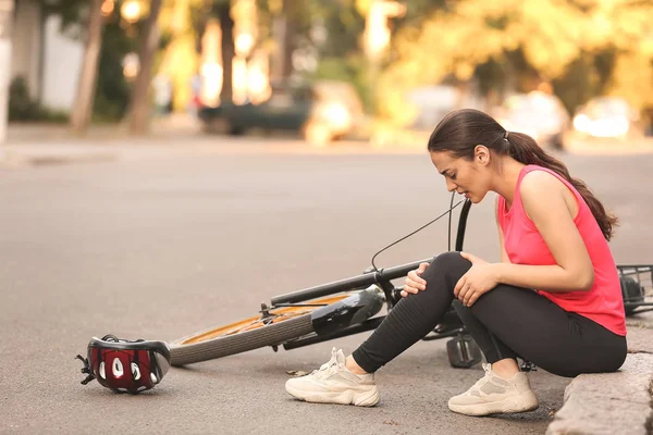 Sportowa młoda kobieta spadła z roweru na zewnątrz — Zdjęcie stockowe