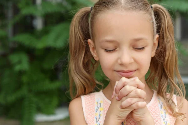 Aranyos kislány imádkozik a szabadban — Stock Fotó