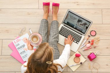 Dizüstü bilgisayar ve kahve fincan ı ile kadın güzellik blogger ahşap zemin, üst görünümü oturuyor