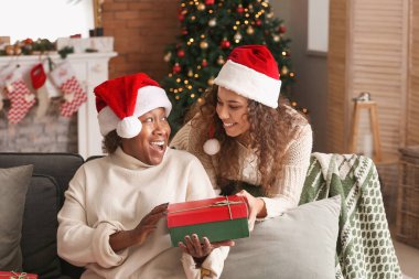 Evde Noel hediyesi ile Afrikalı-Amerikalı kadın ve kızı Portresi