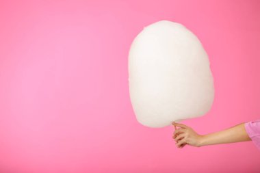 Renkli arka planda lezzetli pamuk şeker ile kadın el