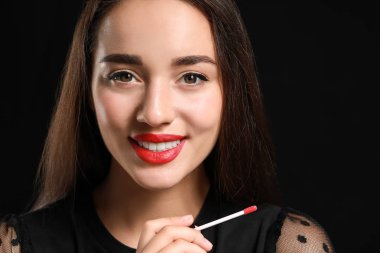 Koyu arka plan üzerinde parlak ruj ile güzel genç kadın