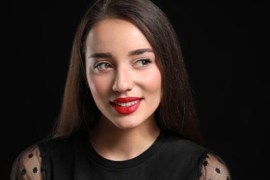 Koyu arka plan üzerinde parlak ruj ile güzel genç kadın