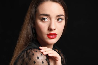 Koyu arka plan üzerinde parlak ruj ile güzel genç kadın