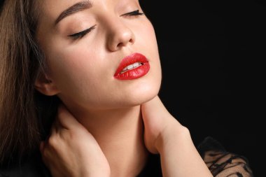 Koyu arka plan üzerinde parlak ruj ile güzel genç kadın