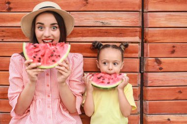 Sevimli küçük kız ve annesi açık havada tatlı karpuz yeme