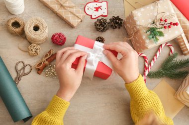 Ahşap masada Noel hediyesi yapan kadın