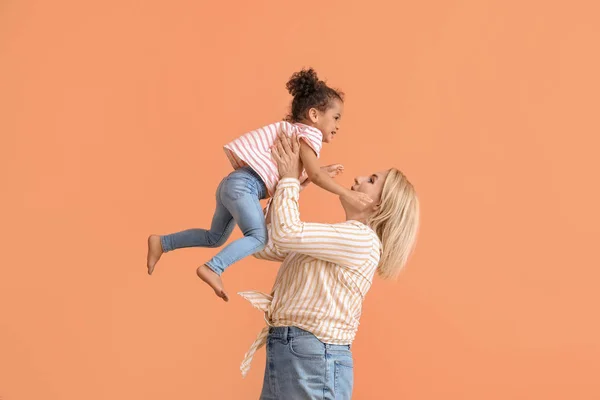 Happy woman and her little African-American daughter on color background — Stock Photo, Image