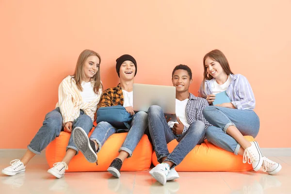 Retrato de jovens estudantes com laptop sentado perto da parede de cores — Fotografia de Stock