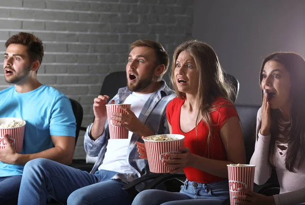 Friends with popcorn watching horror movie in cinema — Stock Photo, Image