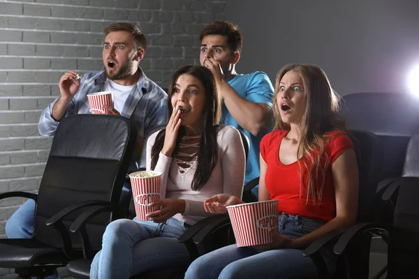 Friends with popcorn watching horror movie in cinema — Stock Photo, Image