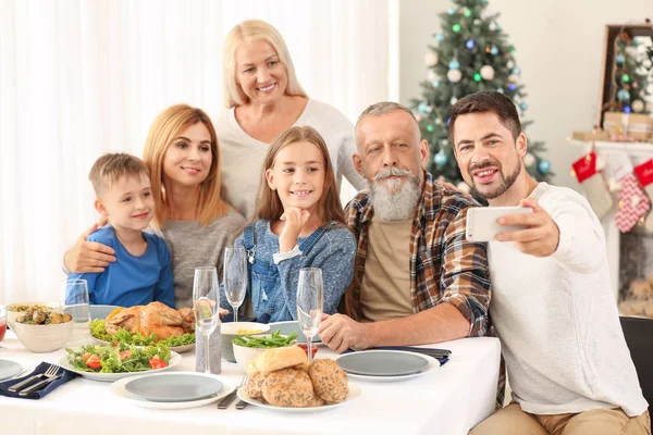 Família feliz tirando selfie durante o jantar de Natal em casa — Fotografia de Stock