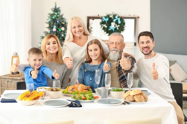 Família feliz mostrando gesto de polegar para cima durante o jantar de Natal em casa — Fotografia de Stock