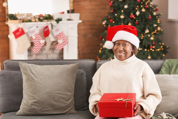 Portrait of African-American woman with Christmas gift at home