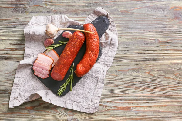 Slate plate with assortment of sausages on wooden table — Stock Photo, Image