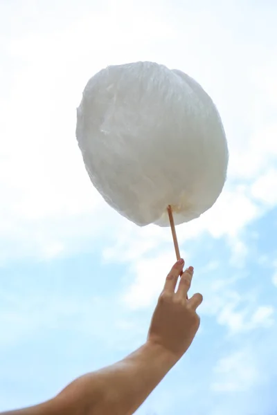 Женская рука с вкусной сахарной ватой на открытом воздухе — стоковое фото