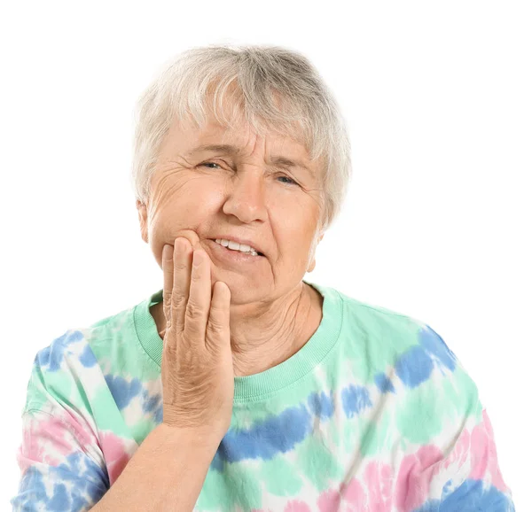 Senior kvinna som lider av tandvärk mot vit bakgrund — Stockfoto