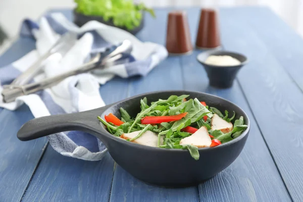 Tigela com saborosa salada de rúcula em mesa de madeira — Fotografia de Stock