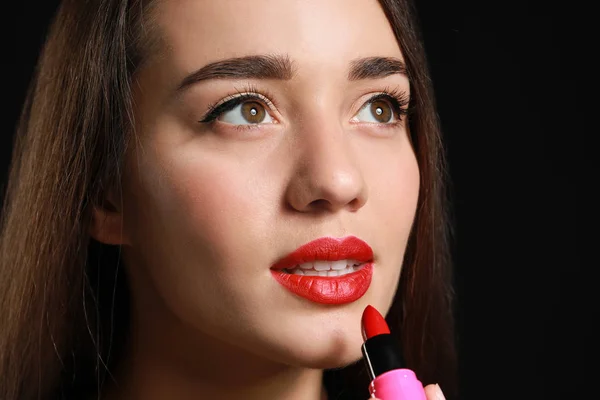 Beautiful young woman with bright lipstick on dark background — Stock Photo, Image