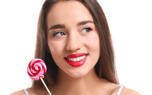 Belle jeune femme avec rouge à lèvres lumineux et sucette sur fond blanc — Photo