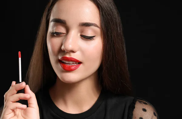 Beautiful young woman with bright lipstick on dark background — Stock Photo, Image