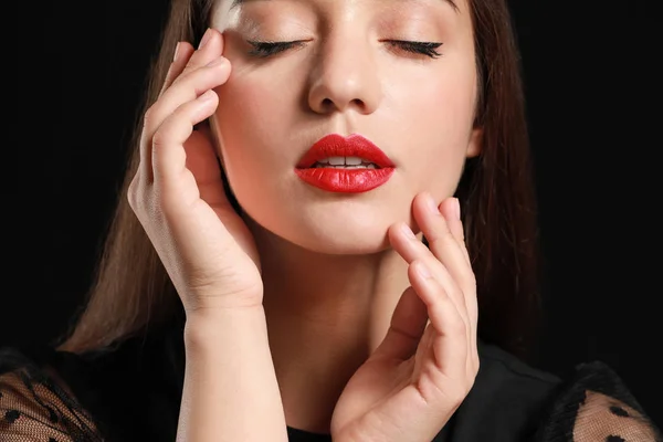 Beautiful young woman with bright lipstick on dark background — Stock Photo, Image