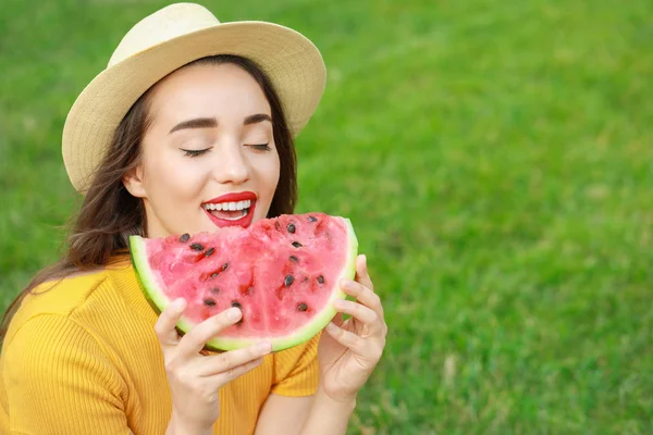 Piękna młoda kobieta jedząca słodki arbuz w parku — Zdjęcie stockowe