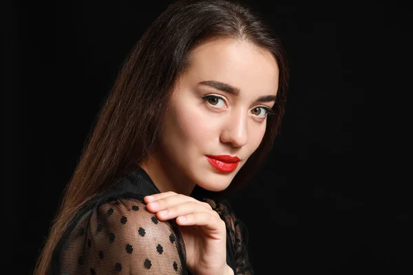 Beautiful young woman with bright lipstick on dark background — Stock Photo, Image