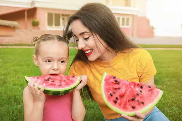 Sevimli küçük kız ve annesi parkta tatlı karpuz yeme — Stok fotoğraf