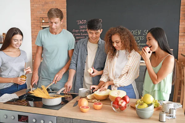 Glückliche Freunde kochen gemeinsam in der Küche — Stockfoto