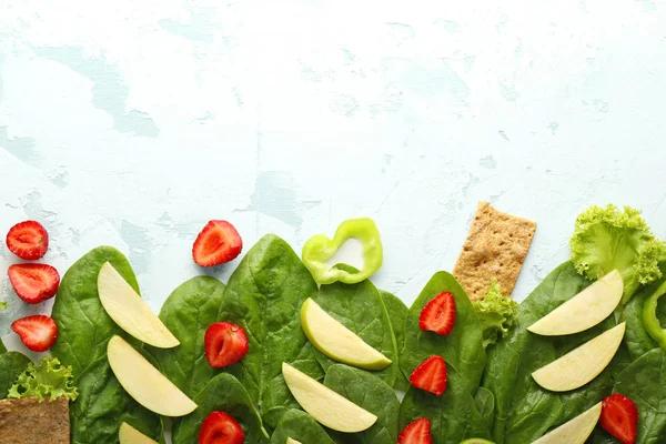 Spinach with strawberry, apple, pepper and crispbread on light background — Stock Photo, Image