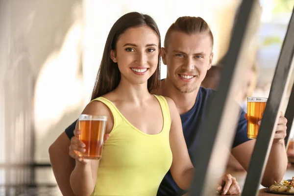Jovem casal bebendo cerveja fresca no pub — Fotografia de Stock