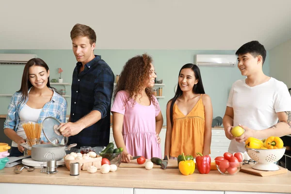 Glückliche Freunde kochen gemeinsam in der Küche — Stockfoto