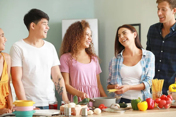 Happy friends cooking together in kitchen — Stock Photo, Image