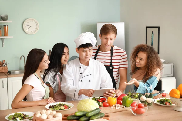 Азиатский шеф-повар и группа молодых людей во время кулинарных занятий — стоковое фото