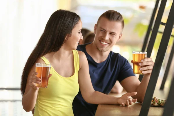 Pareja joven bebiendo cerveza fresca en el pub — Foto de Stock