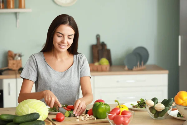 Beautiful young woman cooking in kitchen — Stock Photo, Image