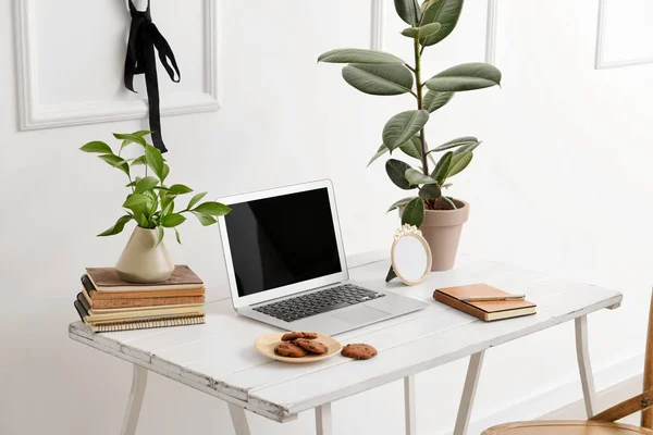 흰색 벽 근처에 현대적인 노트북이있는 세련된 직장 — 스톡 사진