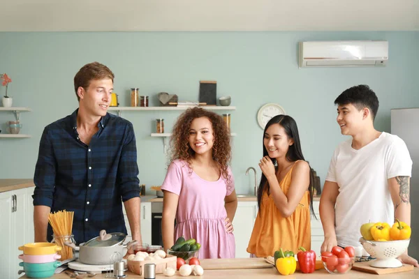 Amigos felizes cozinhar juntos na cozinha — Fotografia de Stock