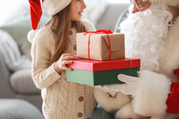 Papai Noel e linda menina com presentes no quarto — Fotografia de Stock