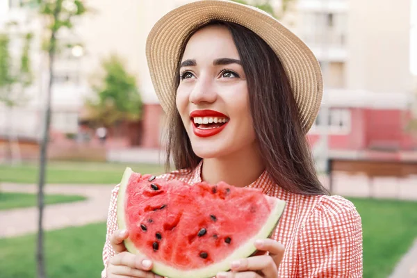 Piękna młoda kobieta jedząca słodki arbuz w parku — Zdjęcie stockowe