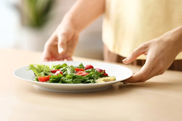 Mulher com salada fresca no prato à mesa, close-up — Fotografia de Stock
