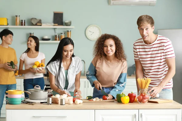 Happy friends cooking together in kitchen — Stock Photo, Image