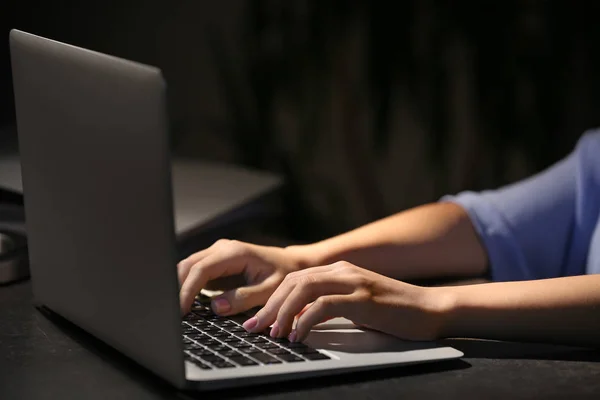 Kvinna som arbetar på laptop vid bordet i kväll, närbild — Stockfoto