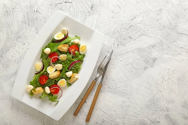 Тарілка зі смачним салатом на світлому фоні — стокове фото